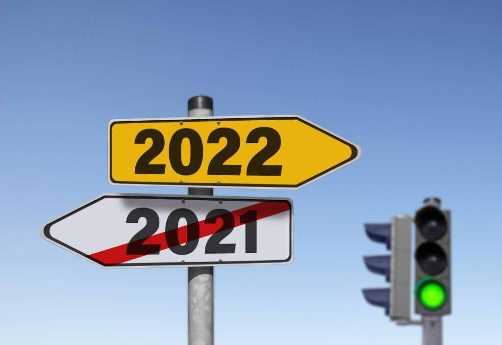 Street sign showing 2021 crossed out and 2022 pointing right